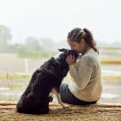 Dame som kysser en border collie på hodet